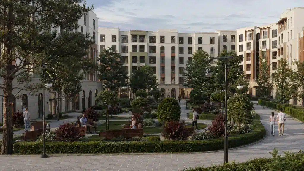 Yürüyüş yolları, oturma alanları, yoğun peyzaj ve modern apartman blokları bulunan konut sitesi iç avlusu
