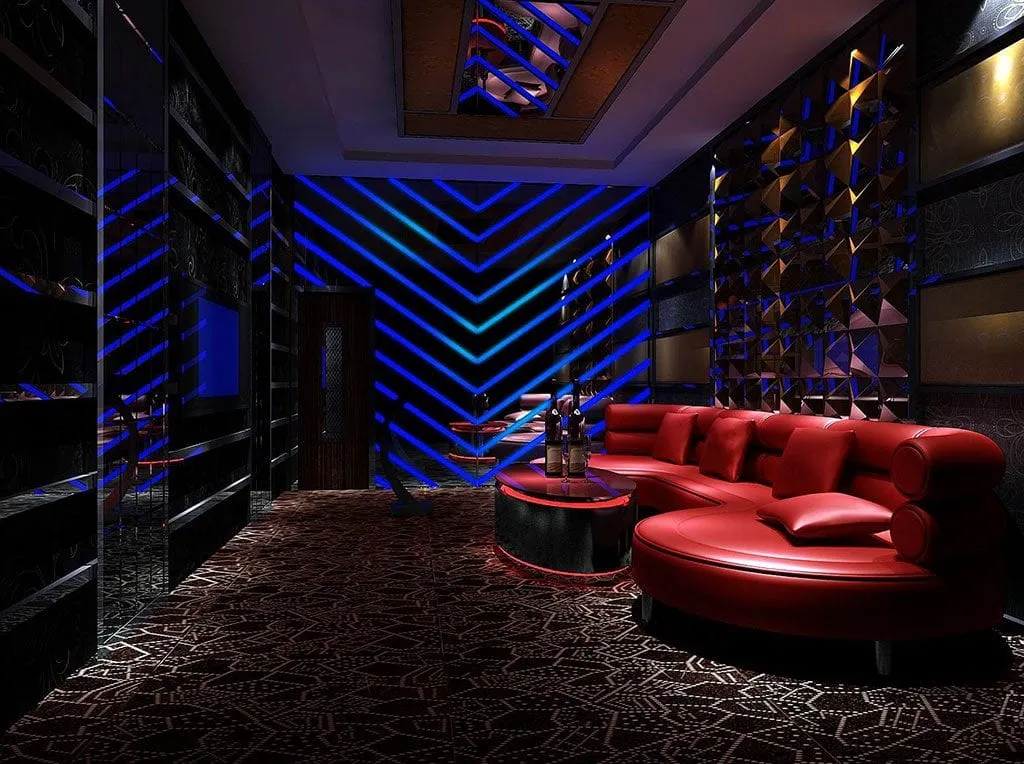 Mavi neon aydınlatmalar, kırmızı oturma grupları ve koyu tonlu yüzeylerle tasarlanan lüks lounge mekânı renderı